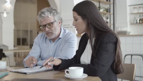 business partners sitting at table with cups