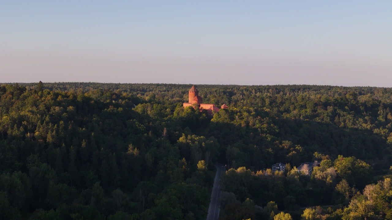 Beautiful Aerial Ascend Over A Fairy Tale Like Castle In The Ancient Forest Of Sigulda, Latvia; Historic Landmark And Tourist Attraction.
