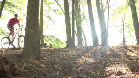 Slow-Motion-Shot-Of-Man-Riding-Mountain-Bike-Through-Woods