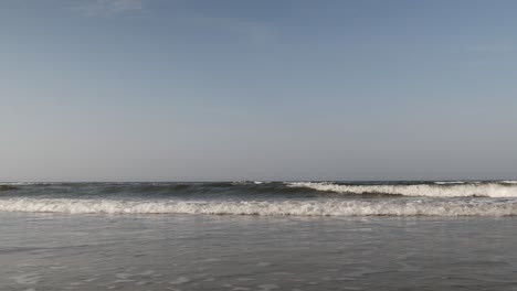 Low-Angle-View-Auf-Meereswellen,-Die-Am-Sandstrand-Rollen