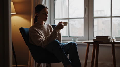 woman enjoying a hot drink by the window