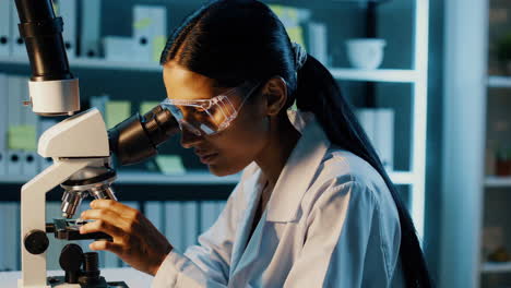 female scientist working with microscope in lab
