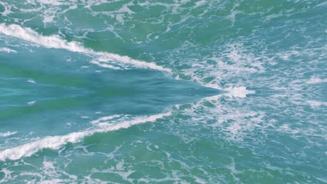 specular dreamy reflection of turquoise water waves, aerial drone flying forward, day