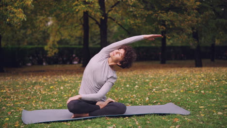 woman practicing yoga in an autumn park