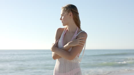 young caucasian woman stands on a sunny beach