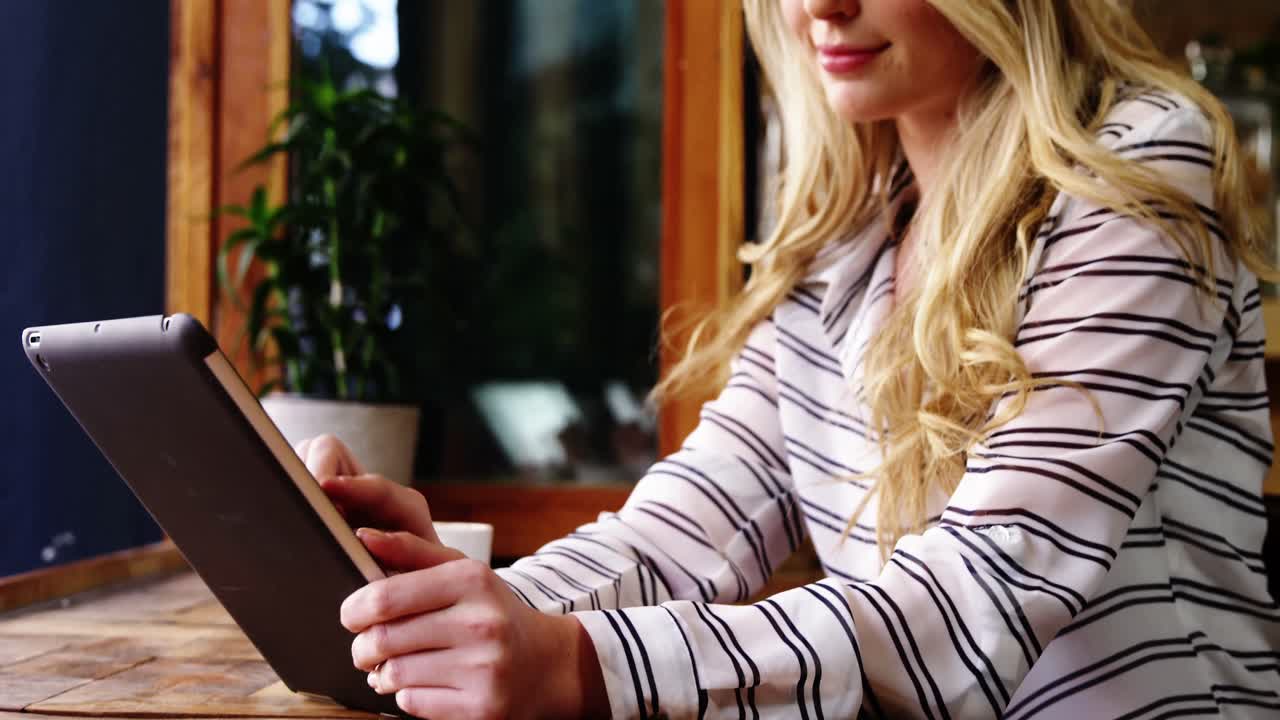 Woman using digital tablet in caf&Atilde;&copy;