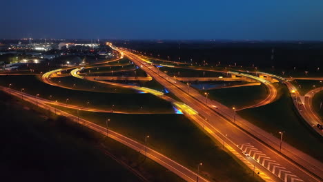 nighttime traffic on cloverleaf freeway junction, aerial dolly in