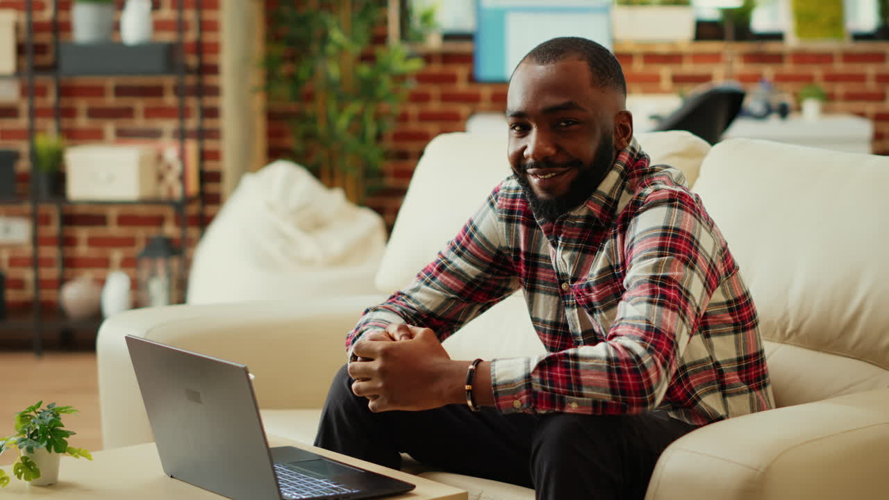 Man sitting on couch using laptop