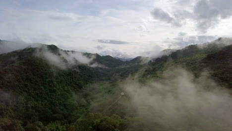 vista aérea volando a través de la mañana lluvia cubierta de nubes selva tropical paisaje montañoso durante la temporada de lluvias en el parque nacional reservado de la montaña doi phuka el norte de tailandia