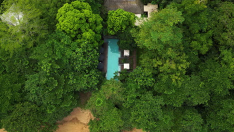 birds eye drone shot tilting over a pool at a beach villa, in principe, africa