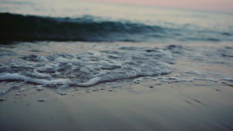 Sea-waves-splashing-sand-beach-on-coastline-in-cold-morning.-Water-surface