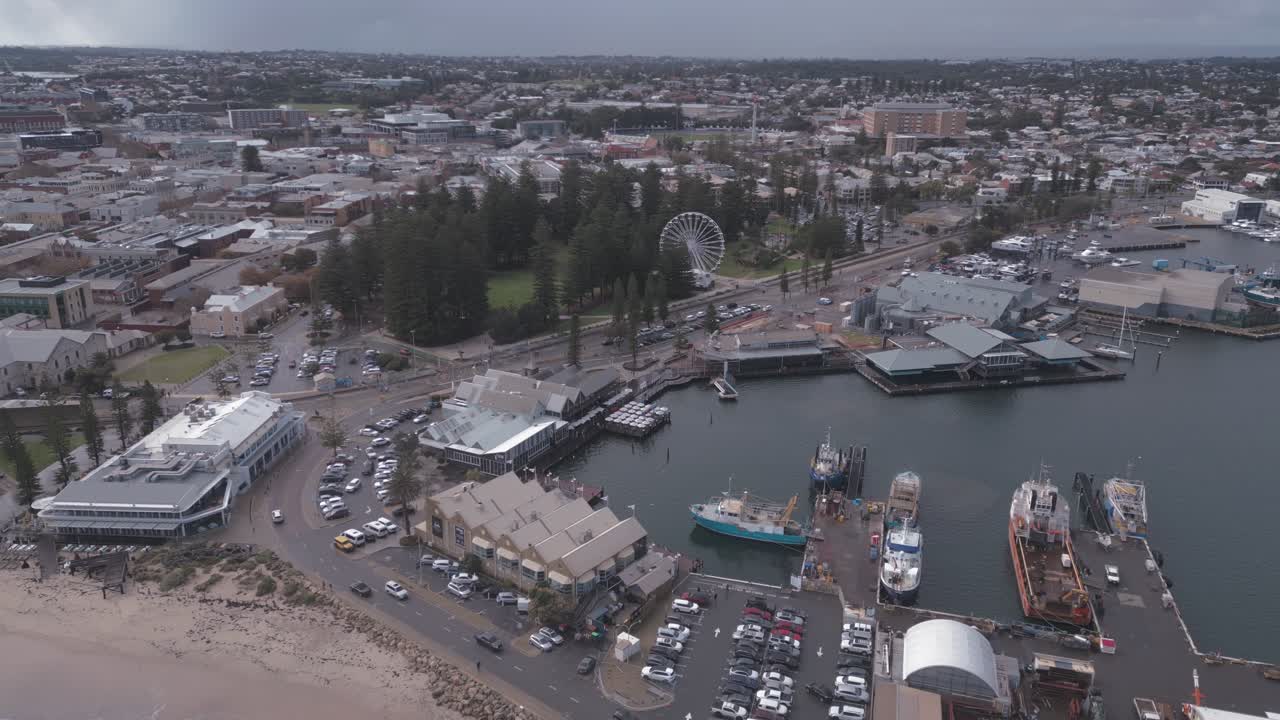 Cinematic aerial footage showing a bird;'s eye view of the Fremantle Docks, Bathers Beach and Esplanade Park in Perth, Western Australia