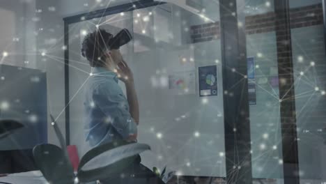 animation of network of connections over businessman wearing vr headset in office