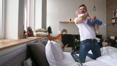 father lying with cute baby daughter on bed at home