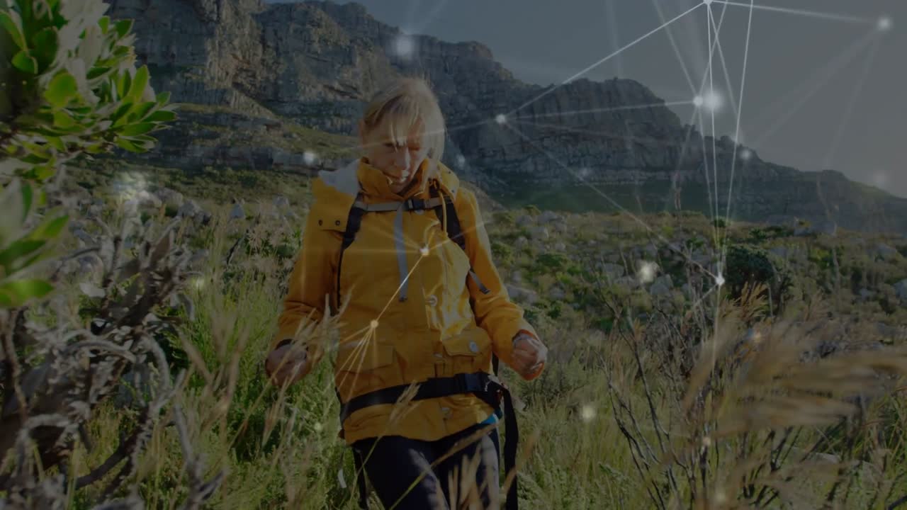 Video verticale: Vedendo un percorso, donna con cappotto giallo e zaino che si fa strada tra la macchia costiera con sovrapposizione digitale