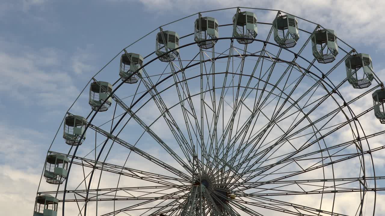 una noria girando contra la luz en el cielo de la tarde en un parque de diversiones