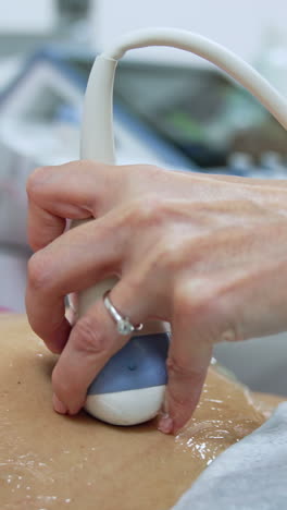 pregnancy examination at ultrasonic equipment. obstetrician moving the device by the little rounded belly of woman. vertical video