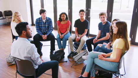 tutor masculino dirigiendo un grupo de discusión entre los alumnos de secundaria