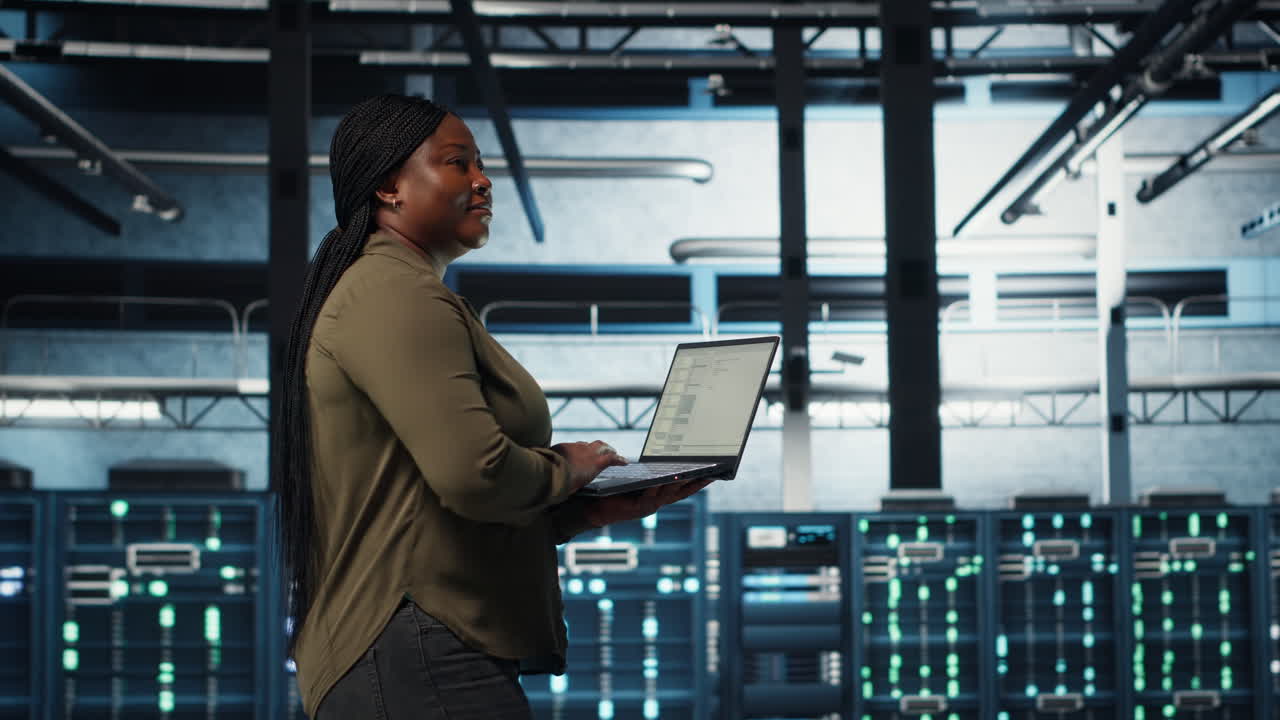 Software developer in data center using laptop to deploy new server architecture