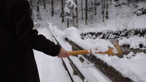 Alguien-Tira-Un-Hacha-Sobre-Una-Barandilla-Con-Nieve-Que-Cae