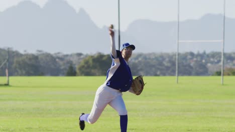 caucasian female baseball player wearing glasses pitching ball on sunny baseball field