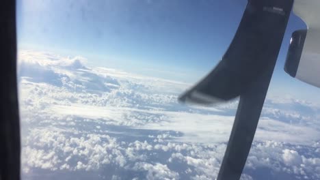 view of clouds looking through window in propeller aircraft