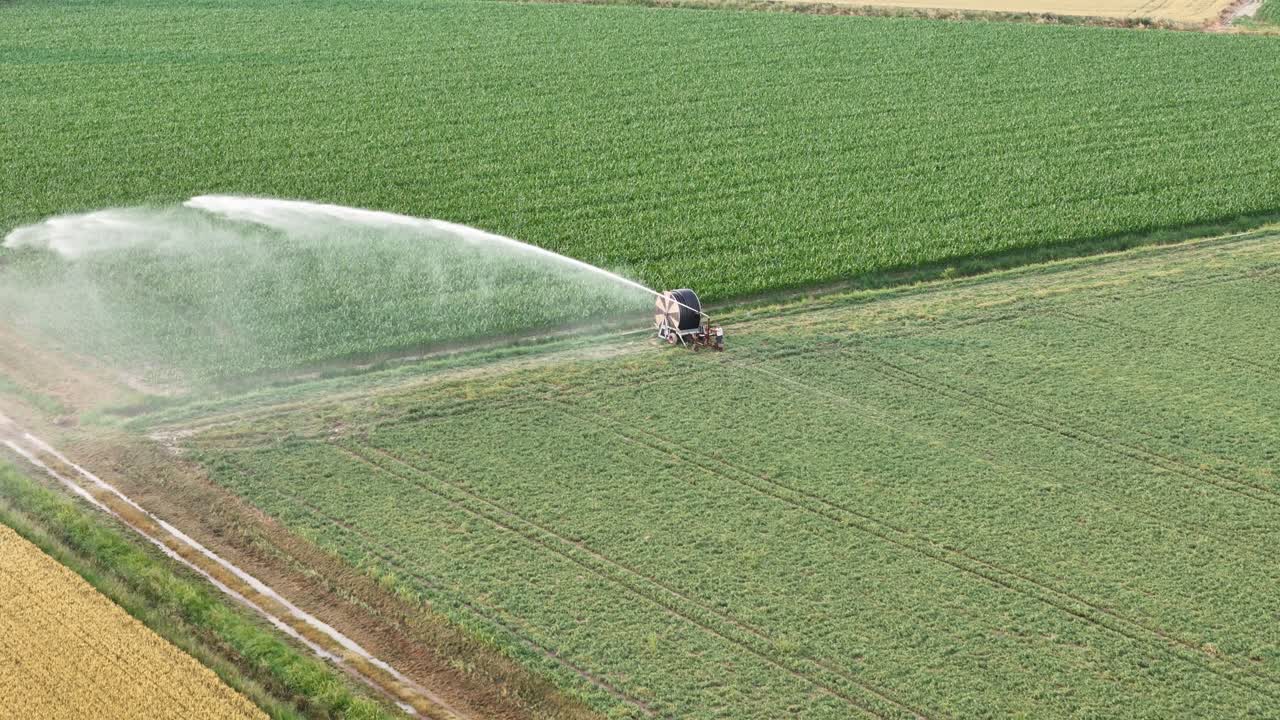 Attrezzatura per l'irrigazione agricola che annaffia le coltivazioni di soia nella Val Padana, in Italia, durante la primavera, fornendo un'idratazione essenziale per una crescita sana al rallentatore, drone in orbita