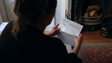 an unrecognizable female opening a debt letter