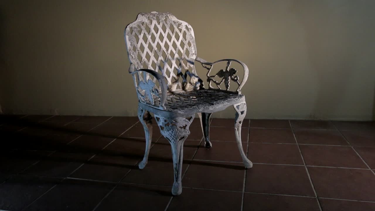Old wrought iron chair set against background