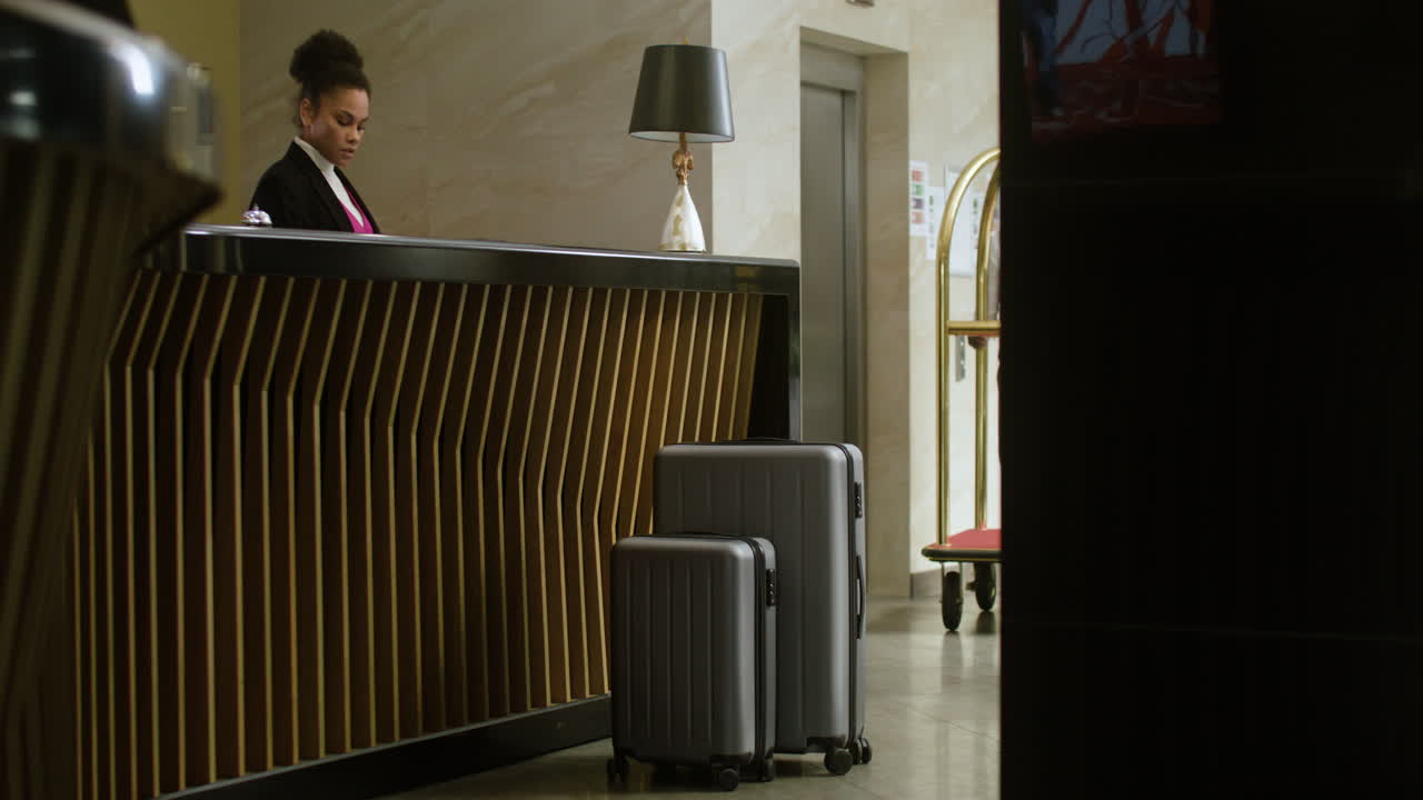 посыльный кладет багаж на тележку в отеле.