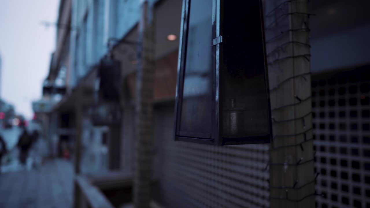 An empty street with modern outside lights and one lonely couple walking.