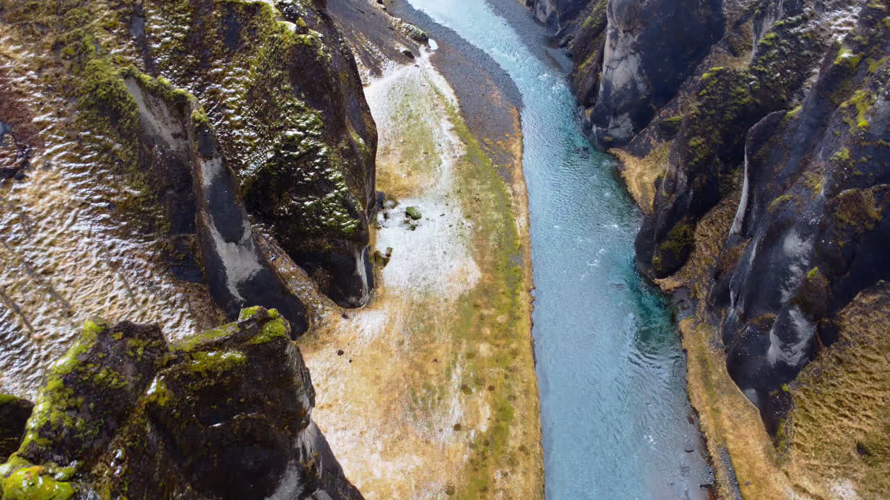 Aerial drone view looking straight down at the turquoise river winding through the dramatic cliffs of Fjaorargljufur Canyon