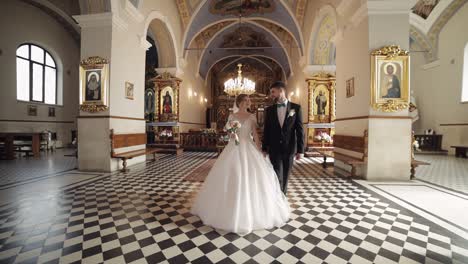 Newlyweds.-Caucasian-bride-and-groom-walking-together-in-an-old-church.-Wedding