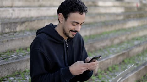 Lächelnder-Mann,-Der-Sein-Smartphone-Auf-Der-Straße-Benutzt