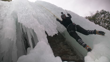 Tiefwinkelansicht-Einer-Person,-Die-Einen-Gefährlichen-Gefrorenen-Wasserfall-Eisklettert