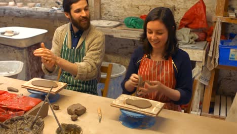 Male-and-female-potters-molding-a-clay