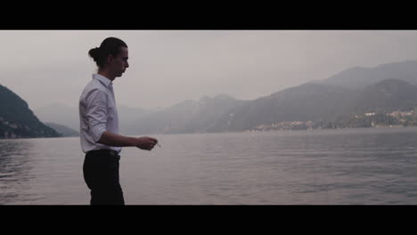 man smoking by a lake