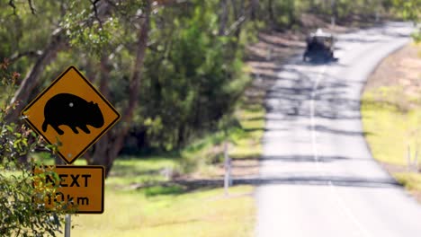 motorcyclist rides past a wildlife warning sign