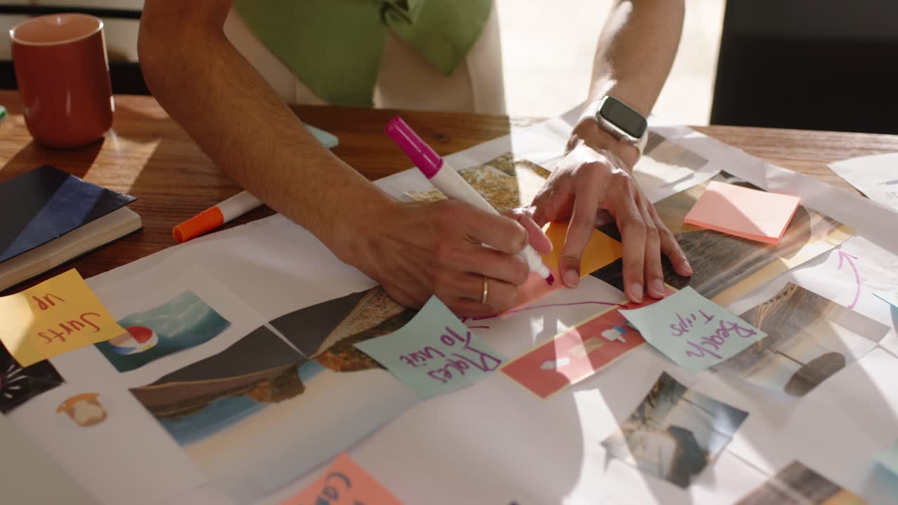 Designer reacting to storyboard unrolling is placing orange sticky notes to map workflow on table