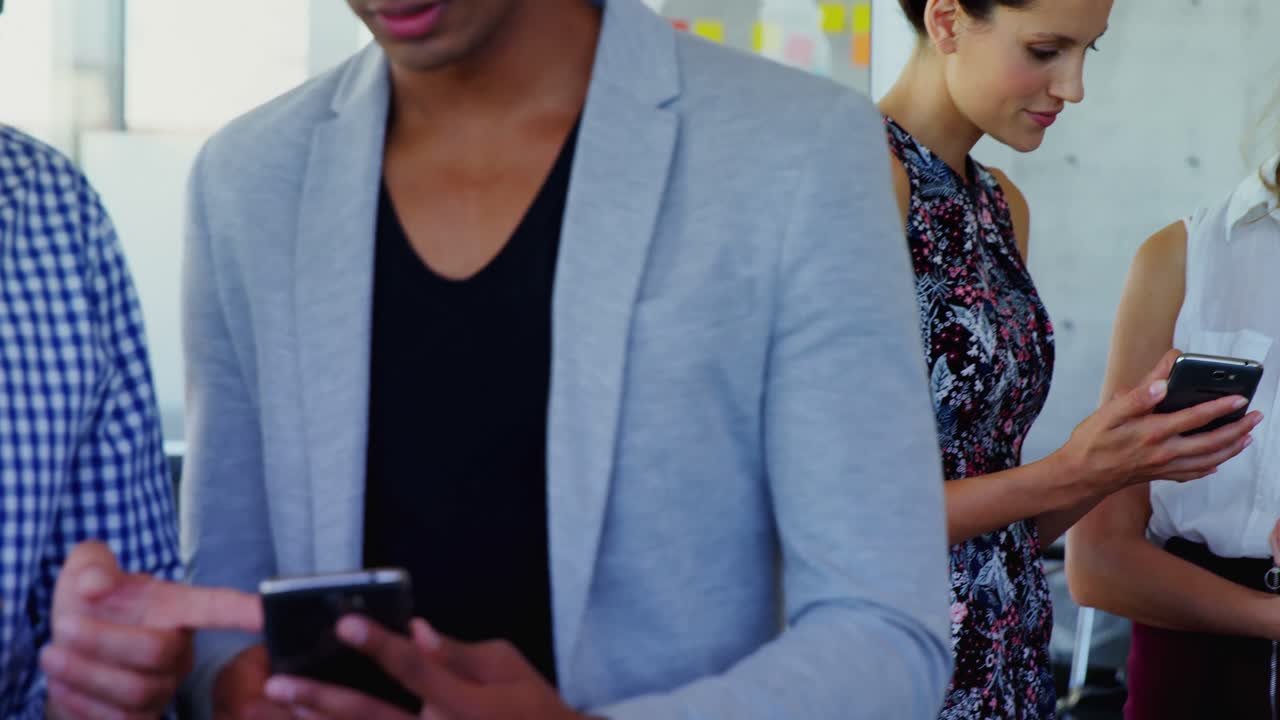 Business executives discussing over mobile phone 4k