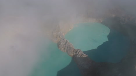 Aerial-reveal-shot-of-the-volcanic-crater-of-Mount-Kelimutu-at-Flores-island,-Indonesia