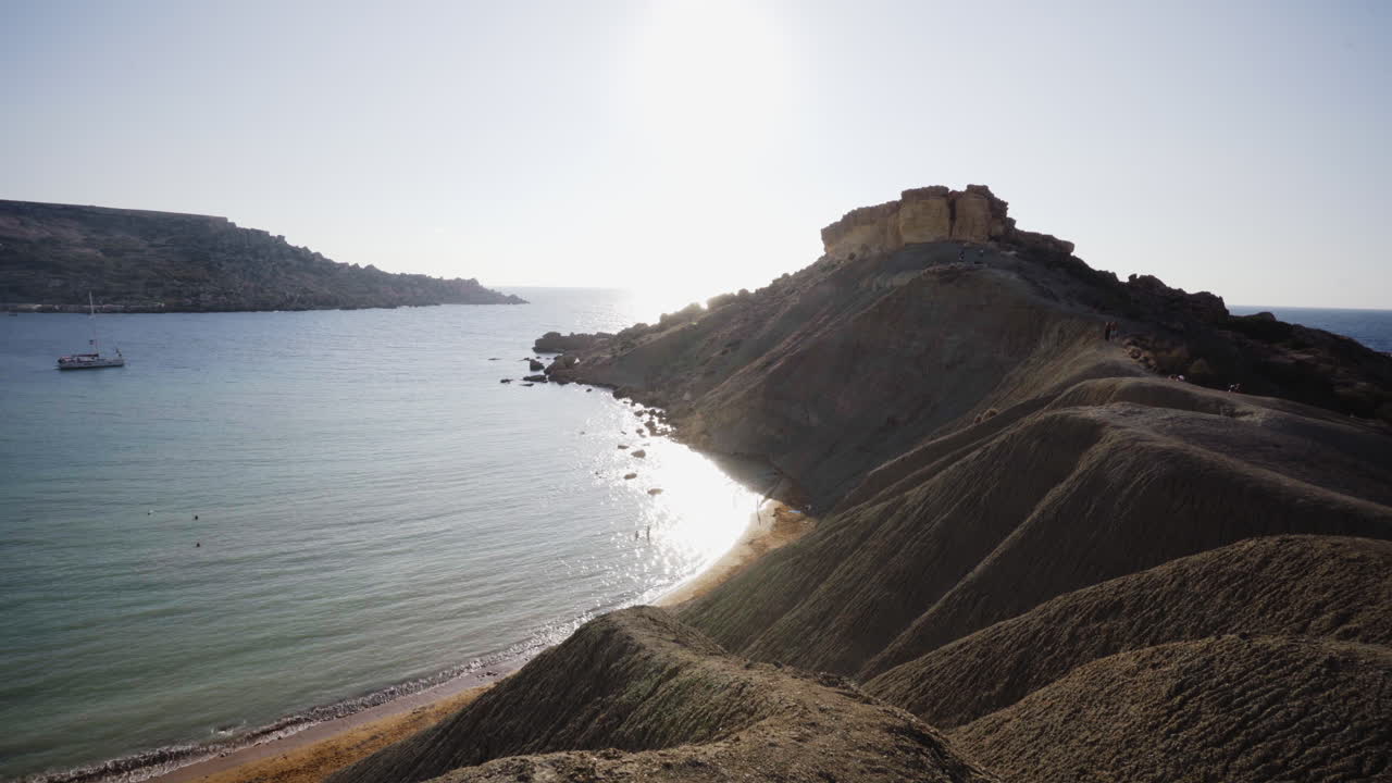 toma panorámica derecha de enormes acantilados de dunas en la costa de malta, agua turquesa