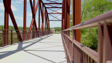 nuevo puente peatonal con vigas de hierro marrón y barandilla recién pintada