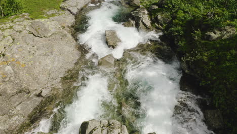 Water-Flowing-At-The-Rocky-Stream-On-A-Sunny-Day-In-Hydalen-Valley,-Hemsedal,-Norway