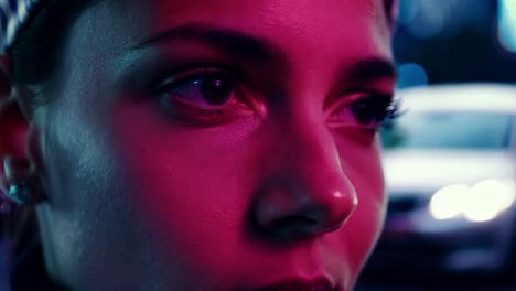 close-up portrait of a woman with neon lighting in the city at night