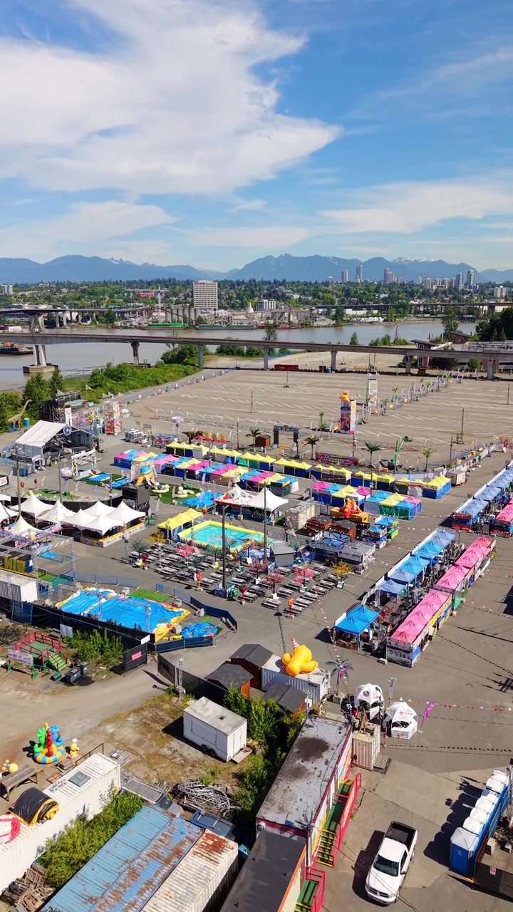 Cảnh ban ngày Chợ đêm Richmond gần sông Fraser với núi ở phía sau, Richmond, BC, Canada. Cảnh quay trên không theo chiều dọc.