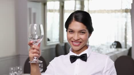 Pretty-waitress-polishing-a-wine-glass