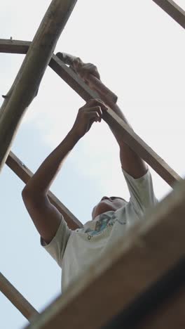 man working on a wooden structure with a hammer
