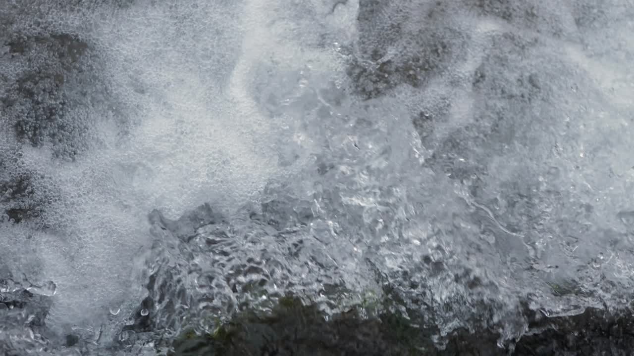 Close-up waterfall, water falling and bubbling slow motion
