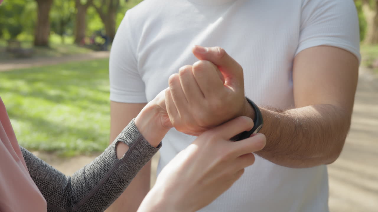pareja en un parque, usando rastreadores de fitness